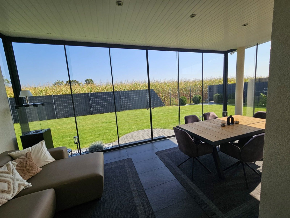Blick durch die Glasschiebewand in den Garten